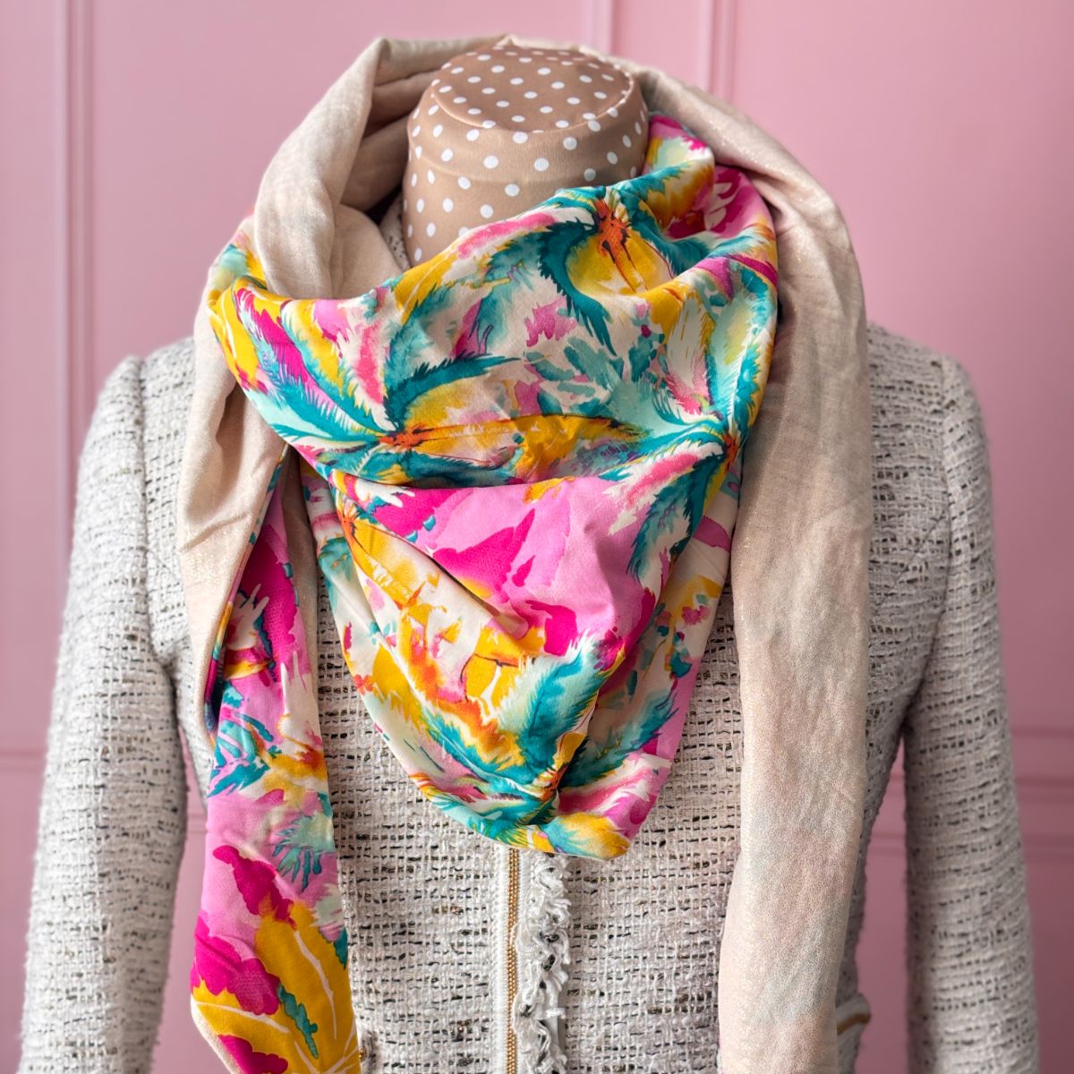 Chèche bicolore de Maison Pivoine sur un mannequin. Un côté en coton imprimé floral vibrant (rose, turquoise, jaune) et un côté en gaze de coton beige brillant avec des fils dorés.