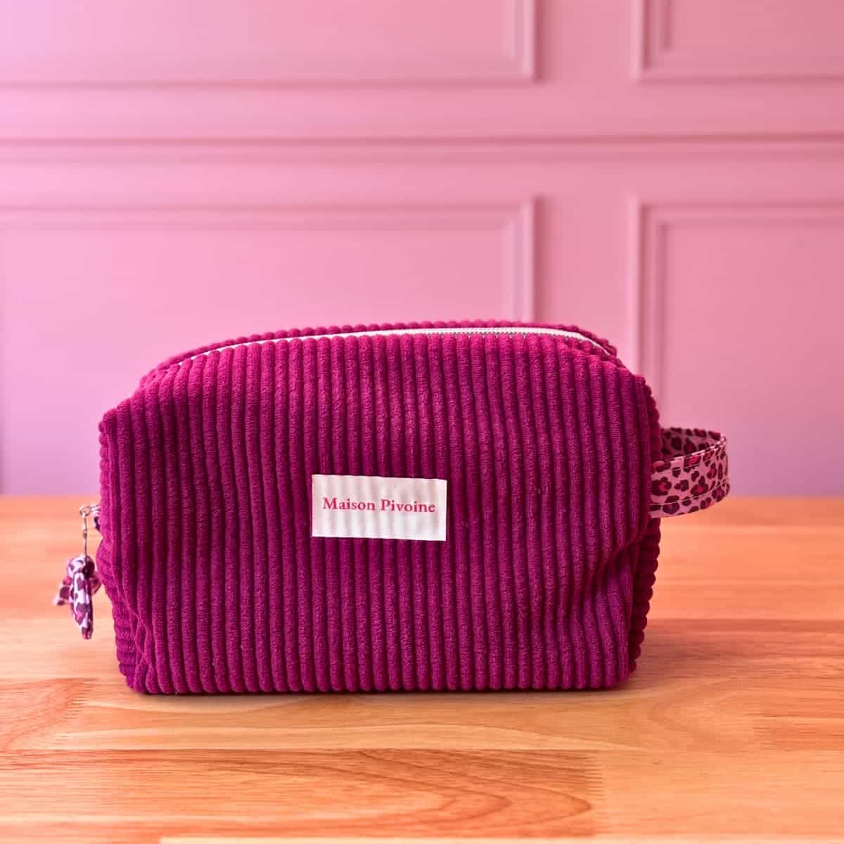 ousse de toilette pour femme en velours violet avec petit nœud léopard sur la fermeture, style élégant et pratique.