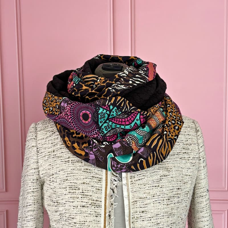 Snood femme double tour très enveloppant, avec un sublime mélange de motifs colorés et sauvages. Porté ici en version bien volumineuse autour du cou, il apporte chaleur et style tout en mettant en valeur une veste claire. Une pièce forte qui réchauffe la tenue tout en restant facile à assortir au quotidien.