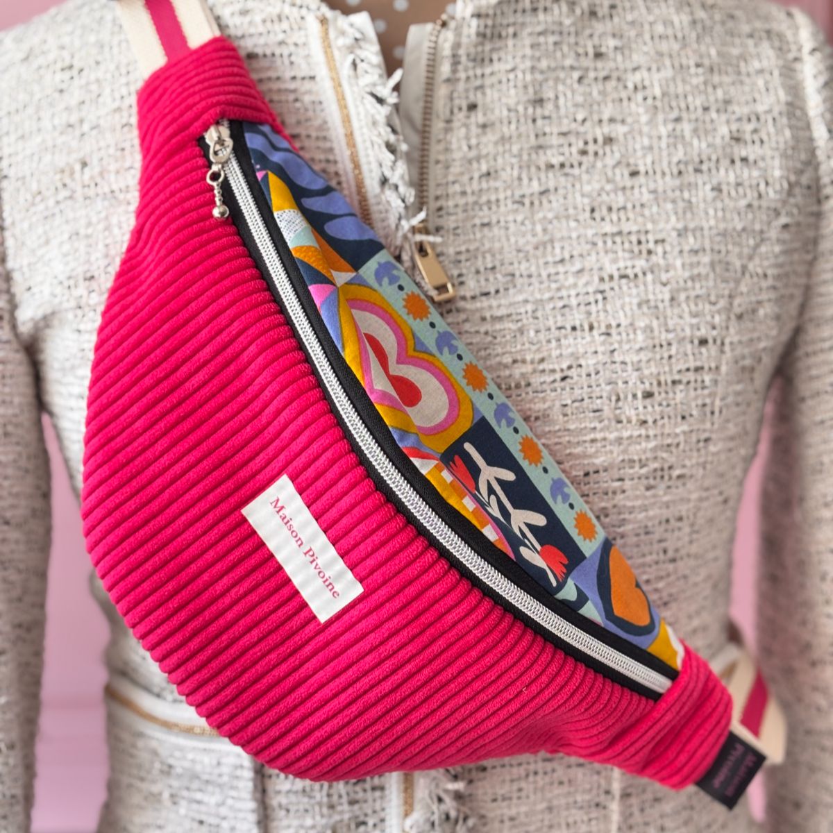 Sac banane velours fuchsia Maison Pivoine présenté sur un mannequin buste portant une veste mouchetée.