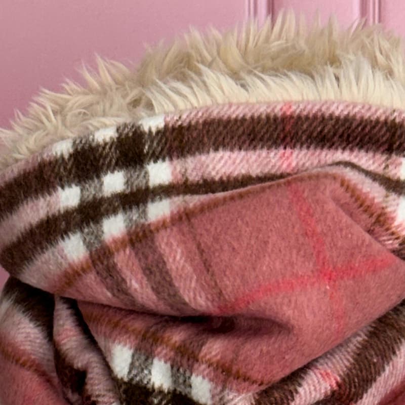 Zoom sur le tissu écossais rose et la douceur de la fausse fourrure crème de l’écharpe snood artisanale