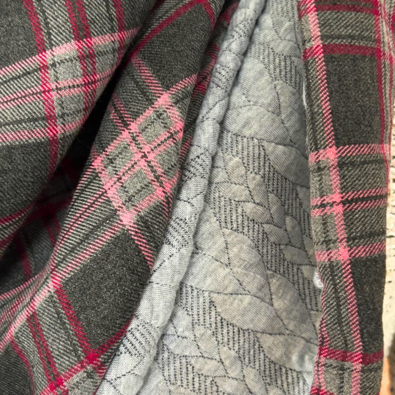 Grand chèche tartan noir et bordeaux pour femme, porté sur mannequin devant un fond rose
