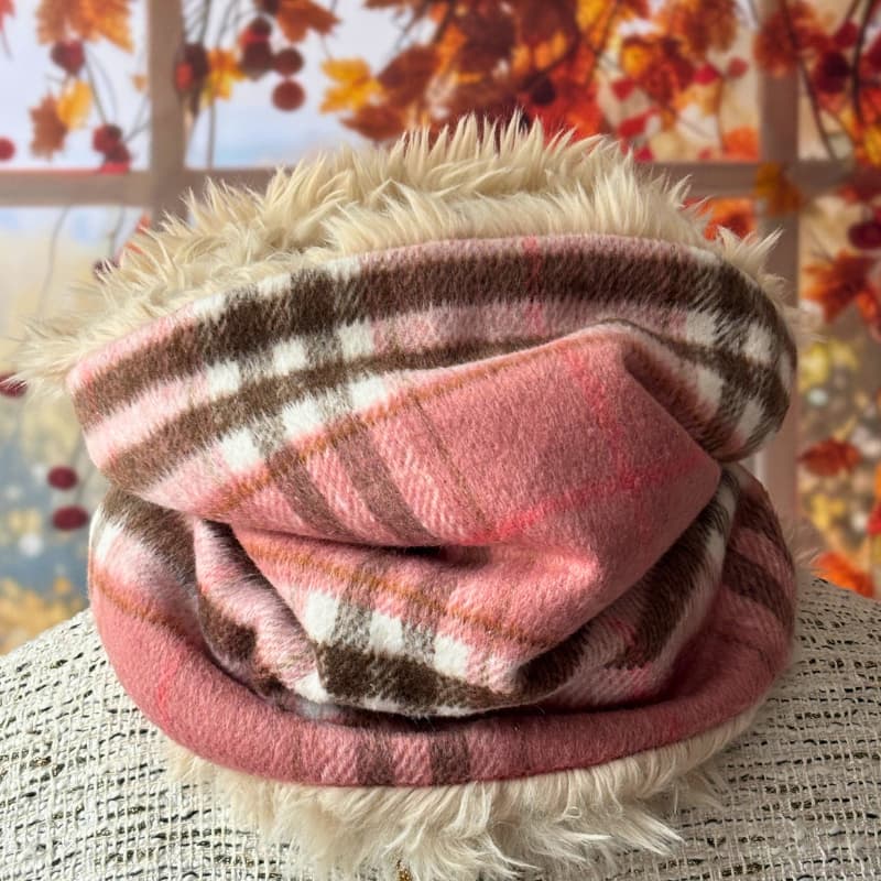 Écharpe snood écossais rose et crème, mise en valeur dans un décor d’automne chaleureux