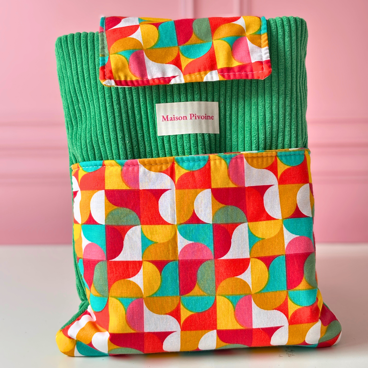 Pochette à roman fait main Maison Pivoine en velours côtelé vert et tissu coton imprimé de formes géométriques colorées orange, jaune, rouge et vert.